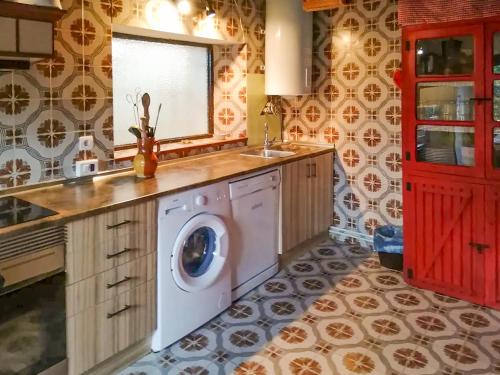 een keuken met een wasmachine en een wastafel bij Charming Casa Rural El Pedregal 