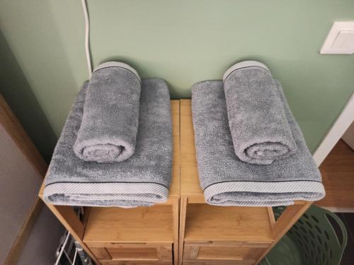 3 toallas en un estante de madera en el baño en Studio cosy, Meaux centre, Disney-Paris, proche gare et activités, en Meaux