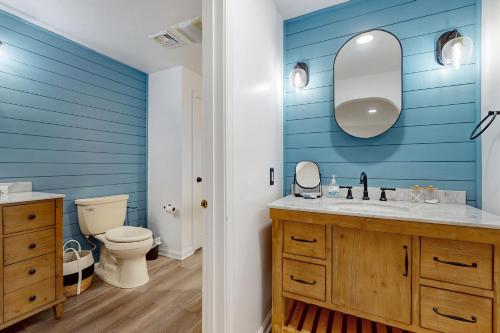 uma casa de banho azul com um WC e um lavatório em Foxglove on Cape em Centerville