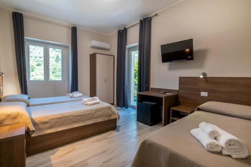 Habitación de hotel con 2 camas y TV de pantalla plana. en Hotel Ristorante La Mimosa, en Lamezia Terme