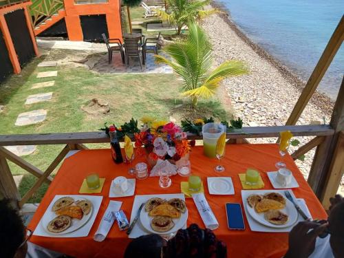 einen Tisch mit Teller mit Lebensmitteln darüber in der Unterkunft Cabañas Mister Mac in Providencia