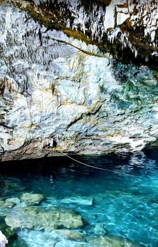 a pool of blue water next to a rocky cliff at Chicxulub Puerto Beach Penthouse in Chicxulub