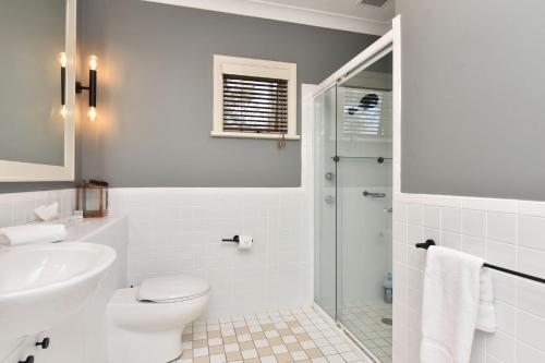 a bathroom with a toilet and a sink and a shower at Villa 2br Bellissimo Villa located within Cypress Lakes Resort in Pokolbin