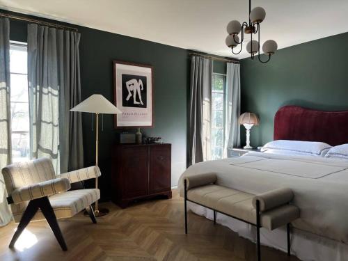 a bedroom with a large bed and a chair at Mr. Nomad: Parisian PopHaus in Uptown in Dallas