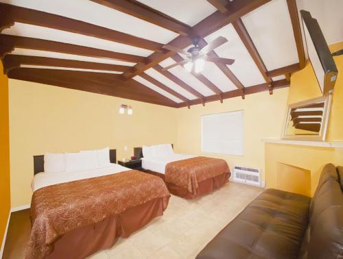 Habitación de hotel con 2 camas y sofá en El Patio Inn - Near Universal Studios Hollywood en Los Ángeles