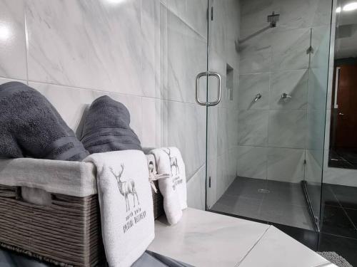 a bathroom with a shower and a chair with towels at CAMSAL Balcon del Valle, Centrico, Comodo y Moderno in Aguascalientes