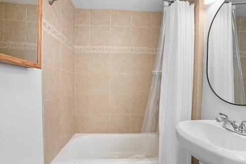 a bathroom with a tub and a sink and a shower at Mission Bay Condo - Steps to Sand, Dining, AC, Parking & Shops! in San Diego