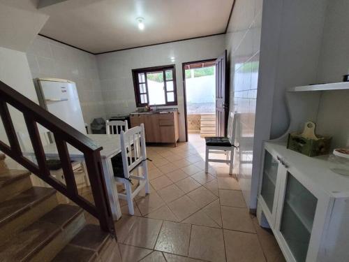 een keuken met een tafel en een keuken met een trap bij Sobradinho Morro das Pedras in Florianópolis