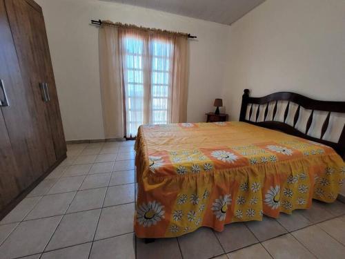 een slaapkamer met een bed met een oranje deken erop bij Sobradinho Morro das Pedras in Florianópolis