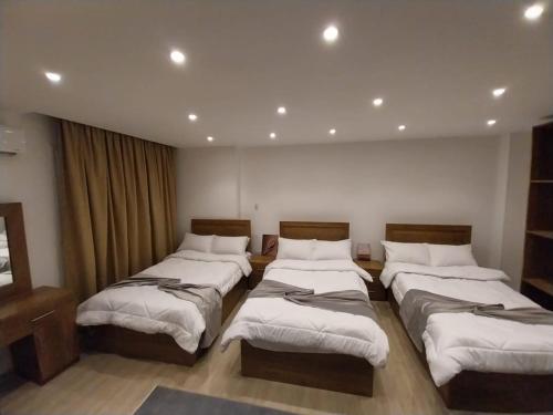 een kamer met vier bedden in een kamer bij Zoser Pyramids View- Foreiigners only in Caïro