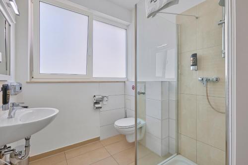 ein Bad mit einem WC, einem Waschbecken und einer Dusche in der Unterkunft Boardinghotel Heidelberg in Heidelberg
