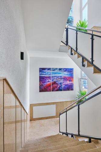 a painting hanging on a wall in a stair case at Boardinghotel Heidelberg in Heidelberg