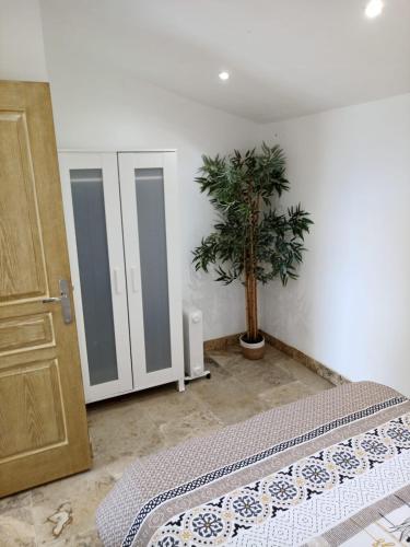 a bedroom with a bed and a potted plant at Appartement lumineux au cœur de la garrigue in Saint-Nazaire