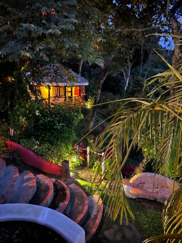 Villa La Fortuna Altos del Maria في Filipina: حديقة في الليل مع منزل في الخلفية