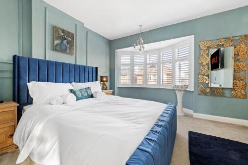1 dormitorio con 1 cama grande y paredes azules en Lovely 2 Bedroom House with Parking, en Loughborough
