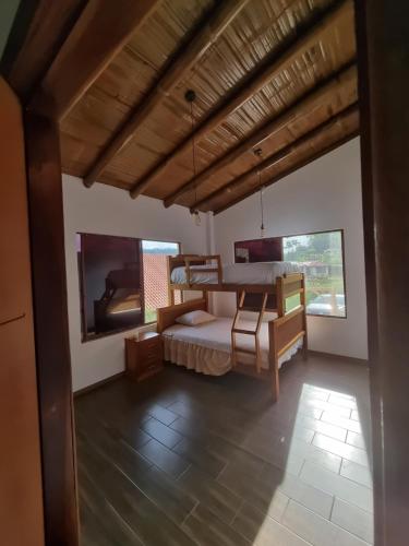 1 dormitorio con 1 cama y 2 ventanas en La Marujita villa de campo en Puerto Quito