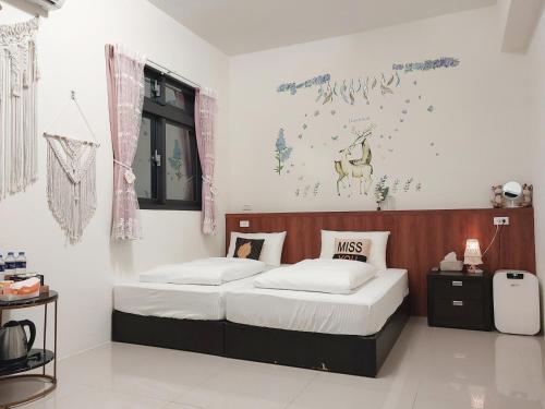 Fengpingにある一宿來民宿のベッドルーム1室(ベッド2台付)が備わります。壁には絵画が飾られています。