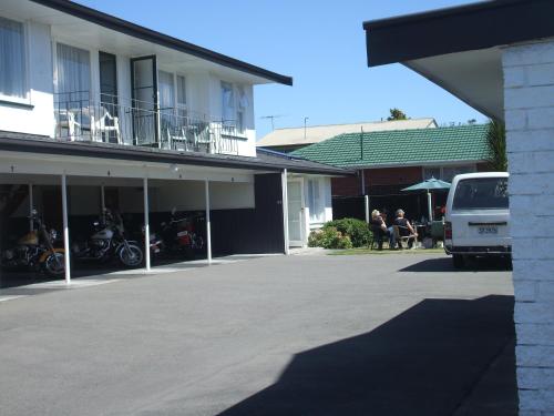 a van parked in a parking lot next to a building at Belle Bonne Motel in Christchurch