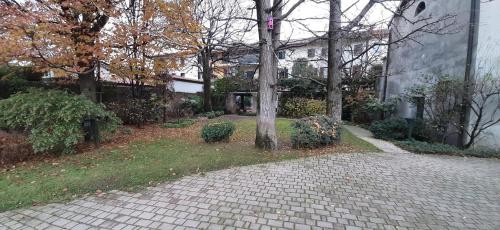 a brick walkway in front of a house with a tree at Appartamento INTERVALLO a 5 min da Aquardens in Pescantina