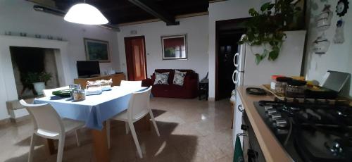 a kitchen with a table and a white table and chairs at Appartamento INTERVALLO a 5 min da Aquardens in Pescantina