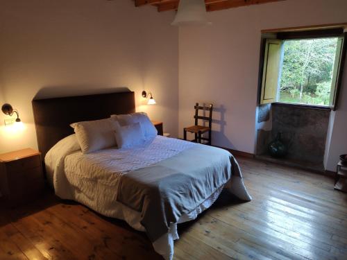 sypialnia z dużym łóżkiem i oknem w obiekcie Casa Moucheiro w mieście Lugo