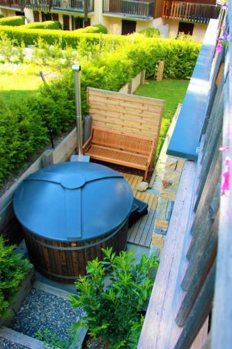 a hot tub and a bench in a yard at Chalet Amour blanc Chamonix Les Houches in Les Houches