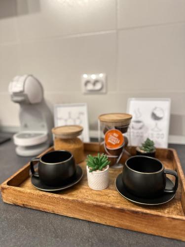 a tray with two black cups and plates on it at Saguna Residence2 in Sighişoara