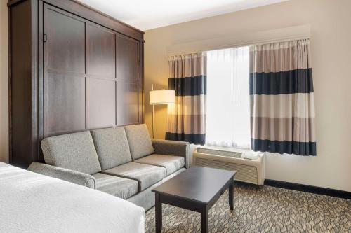 a hotel room with a couch and a window at Best Western Wheatland Inn in Colfax