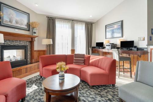 a living room with red furniture and a fireplace at Best Western Wheatland Inn in Colfax