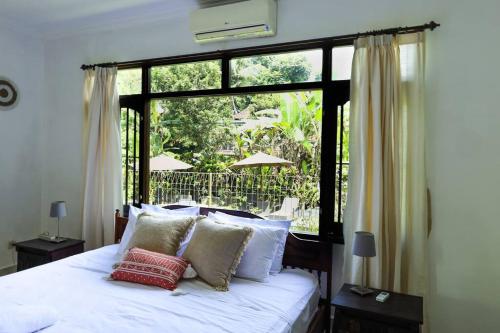 een slaapkamer met een bed en een groot raam bij Spacious 1bd Villa Suite in Penestanan in Ubud