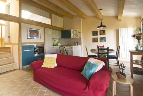 a living room with a red couch and a kitchen at A Prima Vista in Perugia