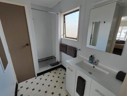 a bathroom with a sink and a mirror at Motel Villa Del Rio in Whangarei