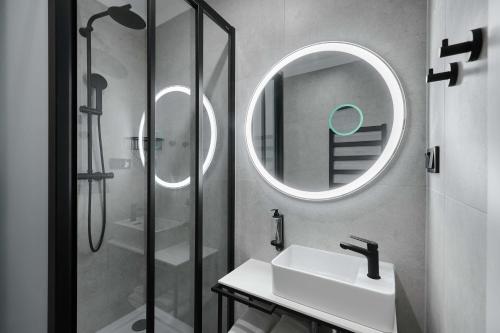 a bathroom with a sink and a shower with a mirror at Best Western Plus Hotel Rzeszow City Center in Rzeszów