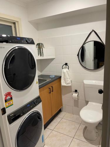 uma casa de banho com uma máquina de lavar roupa e um WC em Luxury Fitzroy House em Melbourne