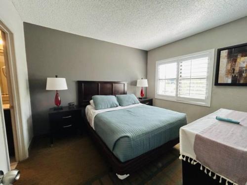 a hotel room with two beds and two lamps at 2BR Condo 1 mile from Universal in Orlando