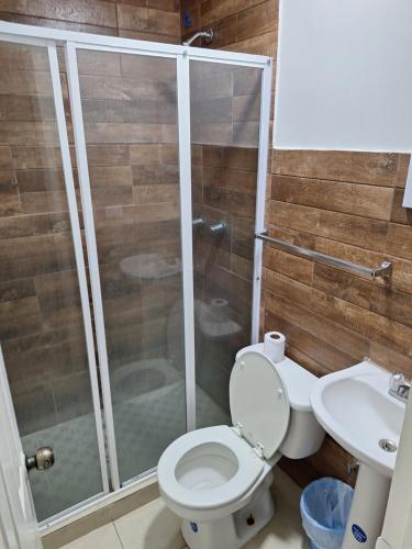 een badkamer met een douche, een toilet en een wastafel bij Express Inn PTY Aeropuerto Internacional Panama in Tocumen