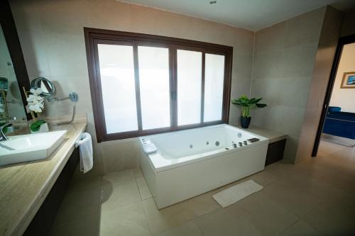 baño grande con bañera y ventana en Playa Paraíso, en Playas