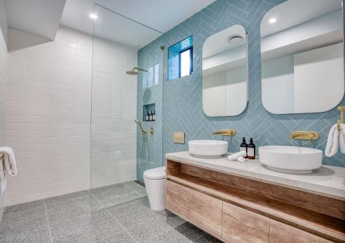 a bathroom with two sinks and a glass shower at Essence Peregian Beach Resort - Lily 4 Bedroom Luxury Home with Private Pool in Peregian Beach