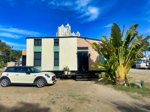 a white car parked in front of a house at Tiny House By The Beach in Mazatlán