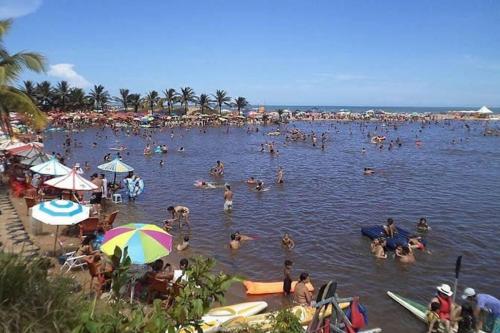 a group of people in the water at a beach at Casa Com Piscina. Prox. Mar e Lagoa Ideal Família in Marataizes