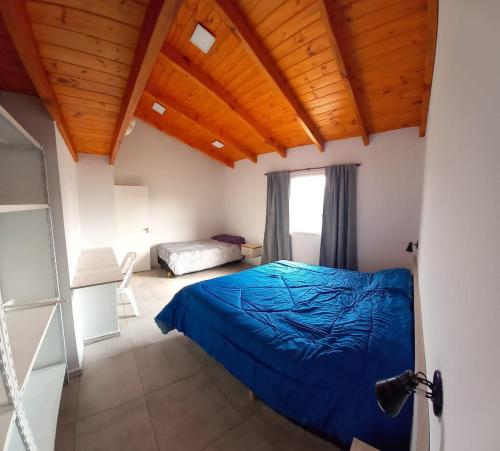 - une chambre avec un lit bleu et une fenêtre dans l'établissement Los Cactus, à Tafí del Valle