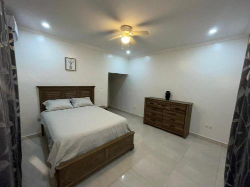 a bedroom with a bed and a ceiling fan at Dream Stay in Brusubi