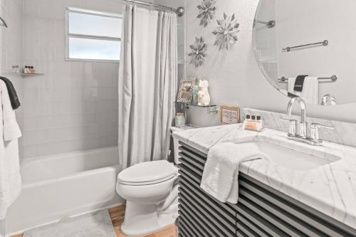a bathroom with a sink and a toilet and a mirror at Riverfront Oasis Stunning Inside and Out Remodeled 3BR Riverfront Home with Hot Tub and personal paddle boats with Access to the Gulf in Riverview