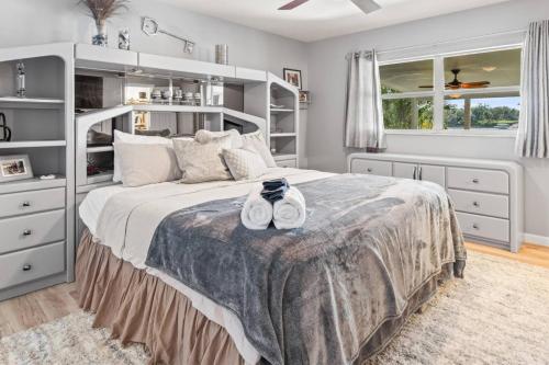 a bedroom with a large bed with white furniture at Riverfront Oasis Stunning Inside and Out Remodeled 3BR Riverfront Home with Hot Tub and personal paddle boats with Access to the Gulf in Riverview