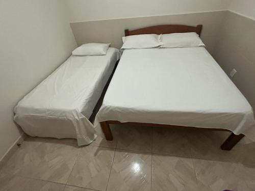 dos camas sentadas una al lado de la otra en una habitación en Apto 2 quartos próx. Floripa Shopping, en Florianópolis