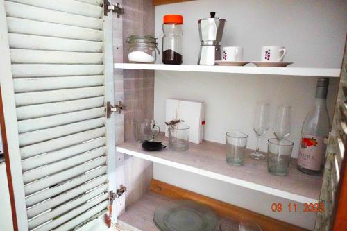 a shelf with glasses and other items on it at Pipí Cucú - Apartamentos Completos in Crespo