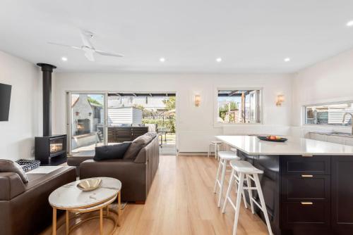 a kitchen and living room with a couch and a table at Coastal Cottage in Queenscliff