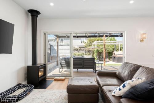 a living room with a couch and a fireplace at Coastal Cottage in Queenscliff