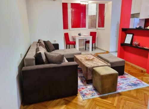 uma sala de estar com um sofá e uma mesa em A&P Apartments em Skopje