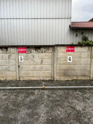 a fence with numbers on it next to a building at Business Hotel Azuma in Hanno